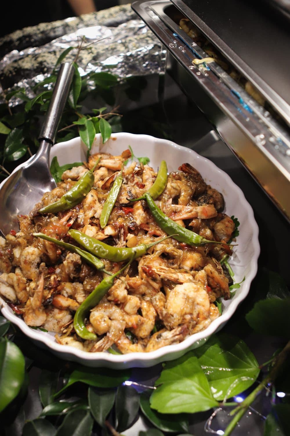 Plated prawns and chillies in a white serving dish